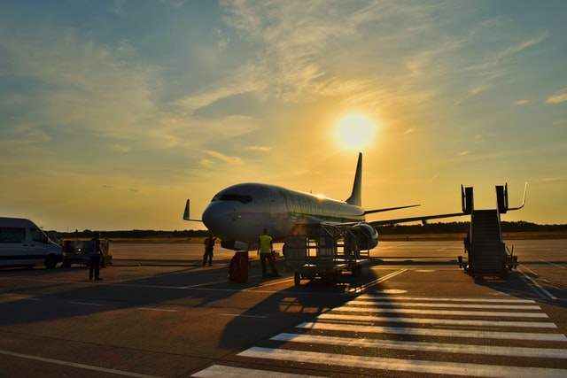 Vliegtuig op vliegveld met ondergaande zon