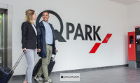 Q-park Schiphol Zwei Kunden vor dem Logo