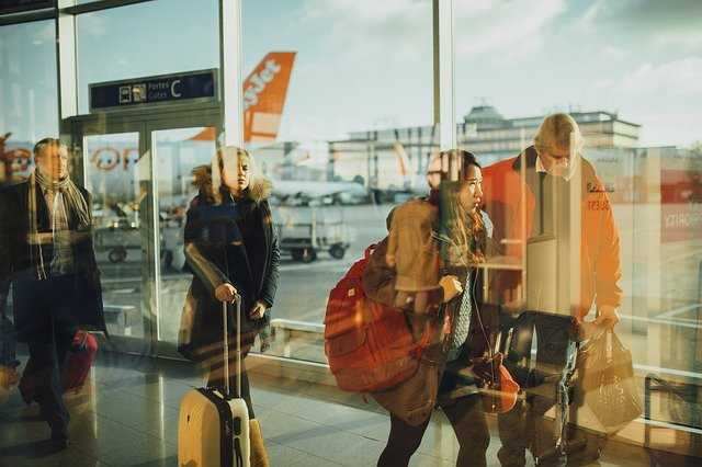 Viaggiatori in aeroporto con aereo Easyjet sullo sfondo.